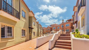 Una calle residencial con una escalera que lleva a una entrada portonada.