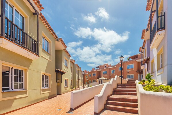 A residential street with a staircase leading to a gated entrance.