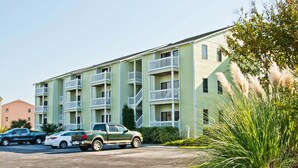 A multi-story building with balconies and a parking area. - Pebble Beach E-102, Oceanview Condo in Emerald Isle, NC! (Emerald Isle)