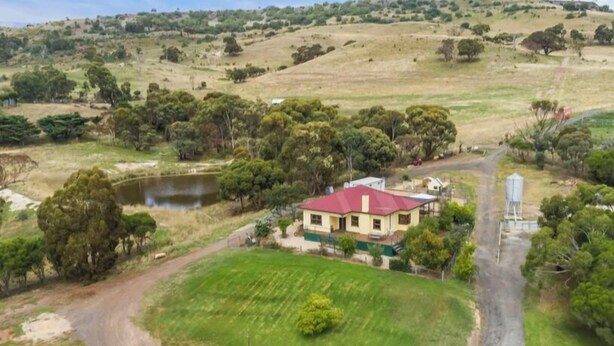 A house with a red roof surrounded by a green lawn and a small pond. - Relaxing farmhouse & panoramic views in Glenmore  (Glenmore)
