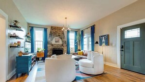 A living room with a fireplace, wooden flooring, and a blue door.