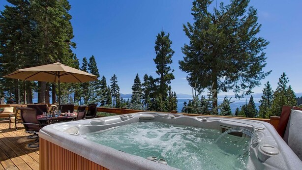 A hot tub on a wooden deck with a view of a lake and trees. - Ramblin' Rose - Lakeview - TLUXP (Tahoe Vista)