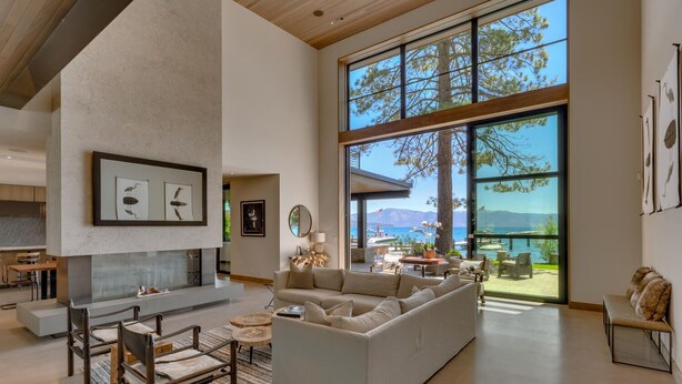 A spacious living room with a fireplace, large windows, and a view of the sea. - Peace of Tahoe - Lakefront - TLUXP (Carnelian Bay)
