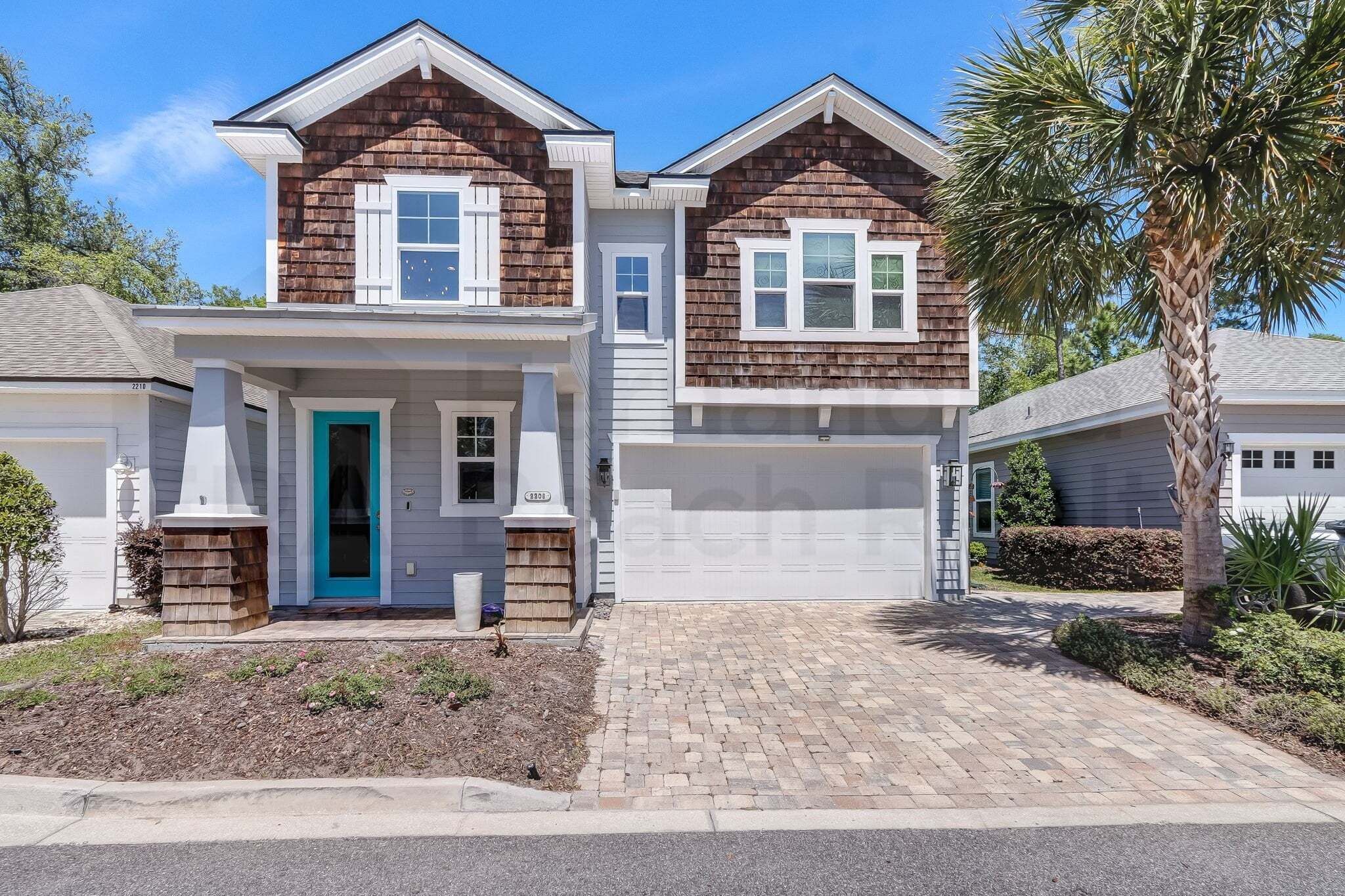 A two-story house with a garage, a front porch, and a driveway.