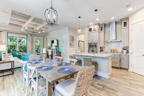 A modern kitchen with white cabinetry, a central island, and pendant lighting.