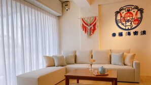 Una sala de estar moderna con un sofá seccional, una mesa de centro de madera y un colgador de pared decorativo de macramé.