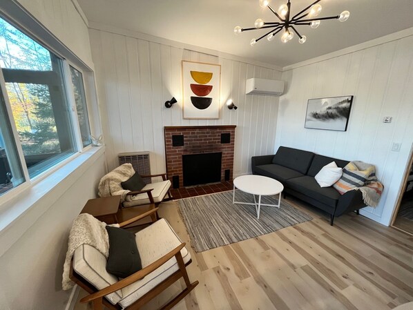 A living room with a fireplace, a sofa, a coffee table, and a chair.