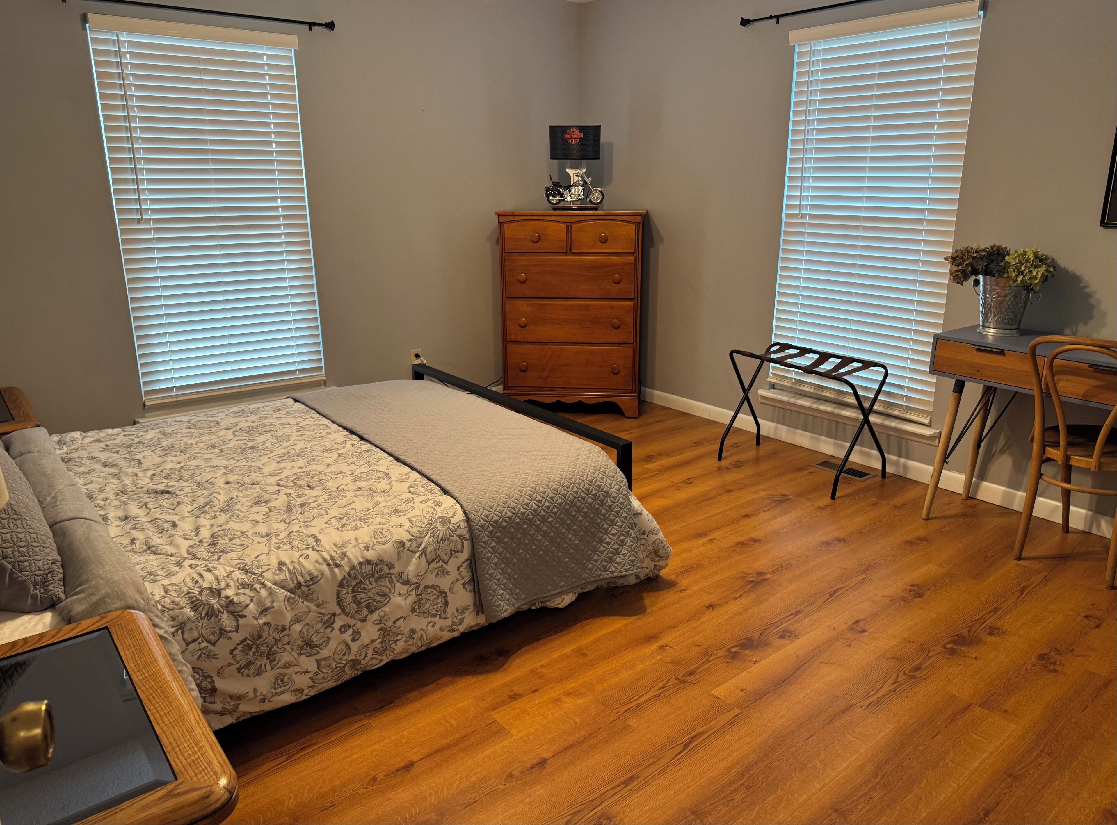 Une chambre à coucher comprenant un lit, une commode, un bureau et une chaise.