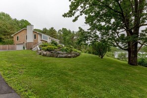 Situated in a serene wooded area, this property offers a tranquil environment with a well-maintained lawn and a small garden.