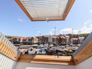A view from a room with a skylight overlooking a marina with boats and buildings in the background. - The Railway Retreat (Whitby)