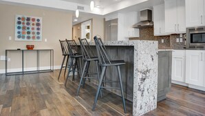 Een moderne keuken met witte kasten, een granieten werkblad en een roestvrijstalen afzuigkap.