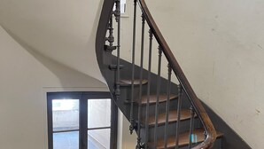 Un escalier en colimaçon avec des marches en bois et des rampes en métal.