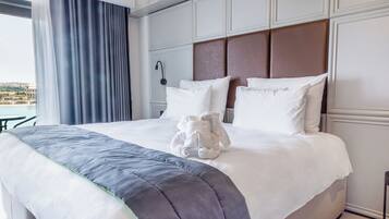 Habitación de hotel con una cama grande, vistas de la ciudad y cortinas.