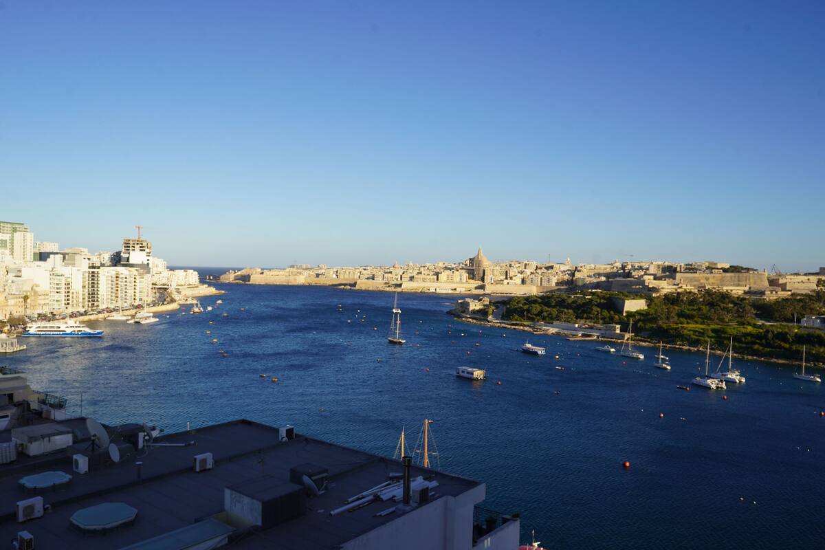 Un puerto con barcos y un paisaje urbano al fondo.