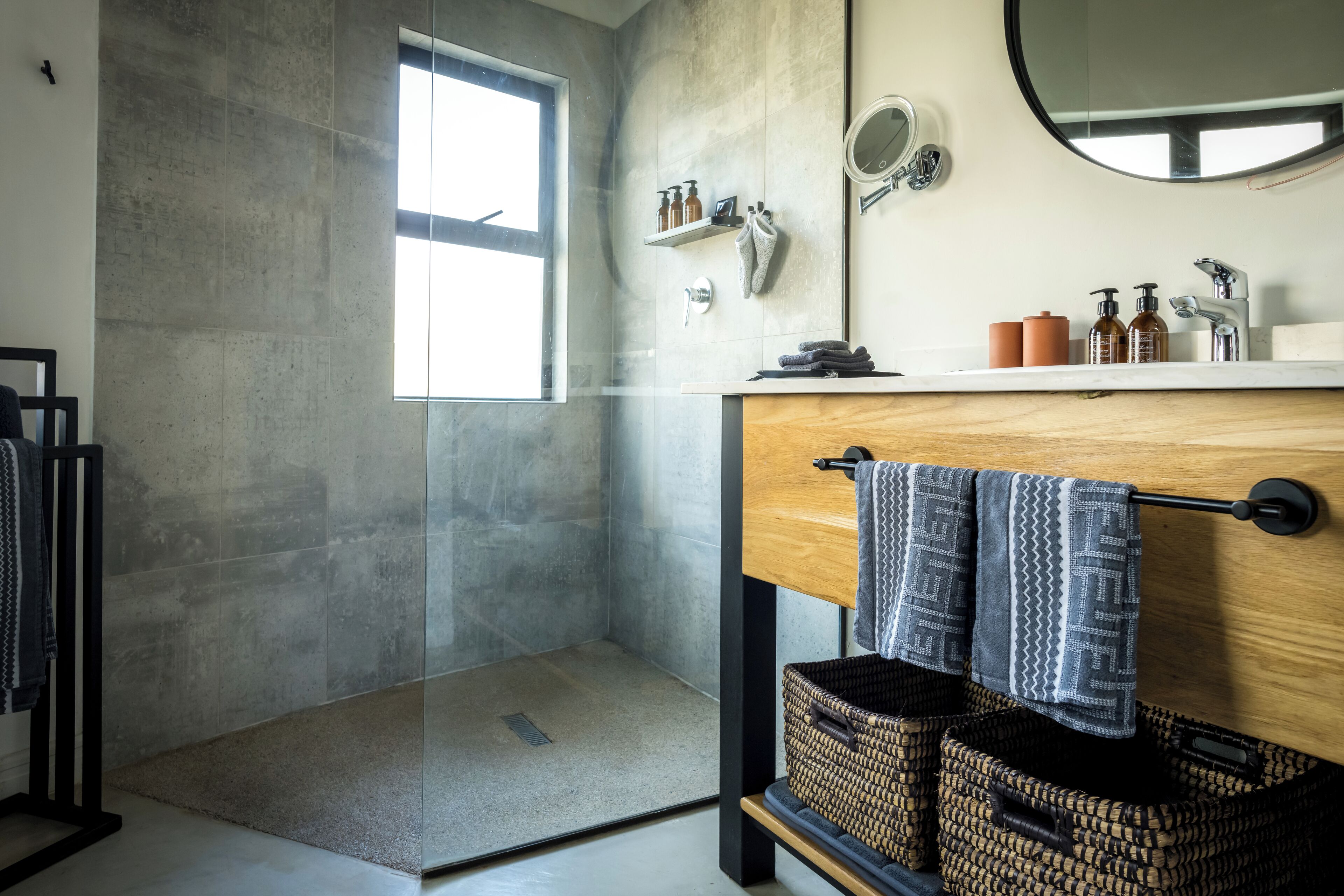 Une salle de bain moderne avec une douche en verre, un meuble-lavabo en bois et un grand miroir.
