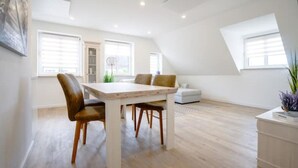 Amplio loft con comedor, sofá y pequeña cocina.