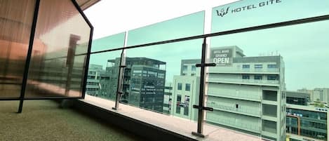 A view from a hotel room with a large window overlooking a modern building labeled "HOTEL GITE."