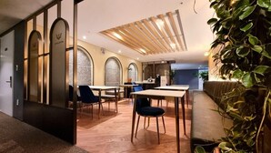 A modern dining area with wooden flooring, tables, chairs, and a ceiling with wooden slats. - HOTEL GITE (Siheung)