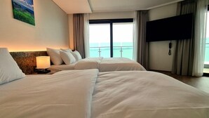 A hotel room with two beds, a TV, and a view of the sea. - HOTEL GITE (Siheung)