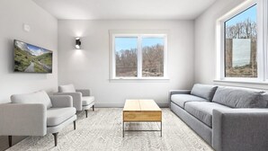 Uma sala de estar moderna com um sofá, uma mesa de centro e um tapete.