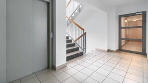 Een modern interieur met een trap, een deur en een betegelde vloer.