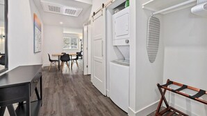 Un intérieur moderne avec un plancher en bois, un bureau noir et un mur blanc agrémenté d’un porte-serviettes mural.