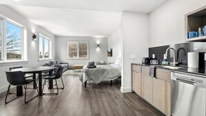 Eine moderne Küche mit Essbereich, einem Bett und großen Fenstern.