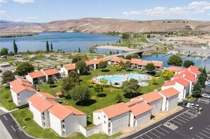 Stunning residential area with a semi-circular pool surrounded by gardens and trees, offering a serene atmosphere.