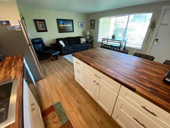 Cozy kitchen and living space with stove, dining table, and comfortable seating area.