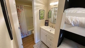 A bedroom with a bunk bed, a bathroom with a shower curtain, and a vanity with a mirror. - #181 Condo near large pool & shuttle to Gorge Amp-book separately (Quincy)