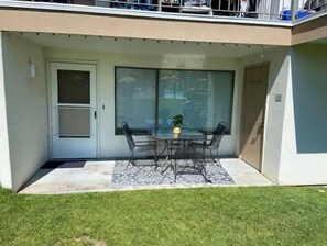 Enjoy a peaceful retreat with a balcony featuring a table for two, a potted plant, and a view of the surrounding area.