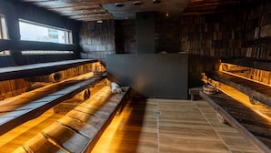 A sauna with wooden benches and a central pillar. - Ring SPA Hostel (Tallinn)