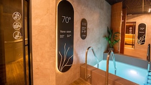 A modern bathroom with a sauna sign indicating 70°C, a pool, and a mirror reflecting the room. - Ring SPA Hostel (Tallinn)