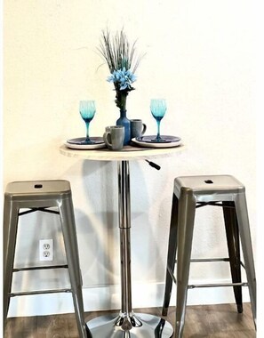 Enjoy a quiet meal for two at this compact dining area with a round table and comfortable stools.