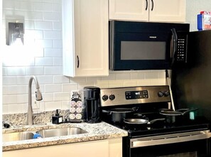 Enjoy cooking in this fully equipped kitchen with a microwave, coffee maker, and kettle.