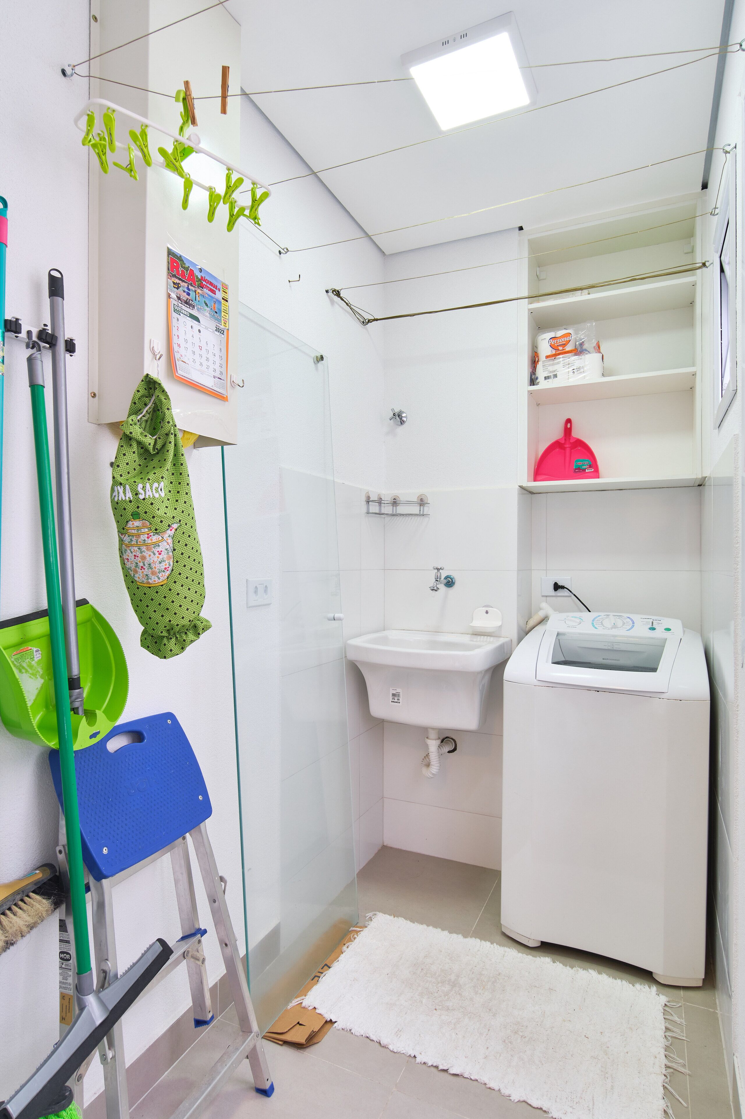 Ein kleines Badezimmer mit Waschbecken, Toilette, Waschmaschine und Dusche.