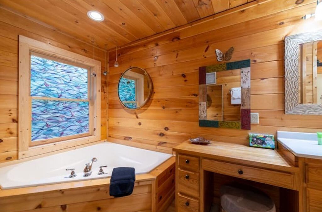 Garden soaking tub in primary suite and area to sit to put on make up