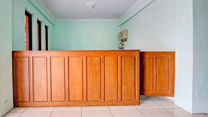 Ein Zimmer mit einem Holzbüro, einem Deckenventilator und einer Leuchte.