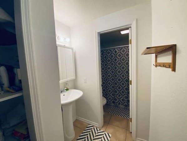 A bathroom with a white sink, a mirror, and a shower area with patterned tiles. - #159 Condo near large pool & shuttle to Gorge Amp-book separately (Quincy)
