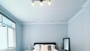 A bedroom with a bed, bedside tables, a mirror, and a window. - Londwell - Luxury Knightsbridge Flat - Harrods (London)