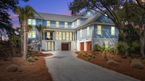 A two-story house with a front porch, a garage, and a driveway.