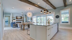 A spacious living area with a large island, a fireplace, and a dining area.