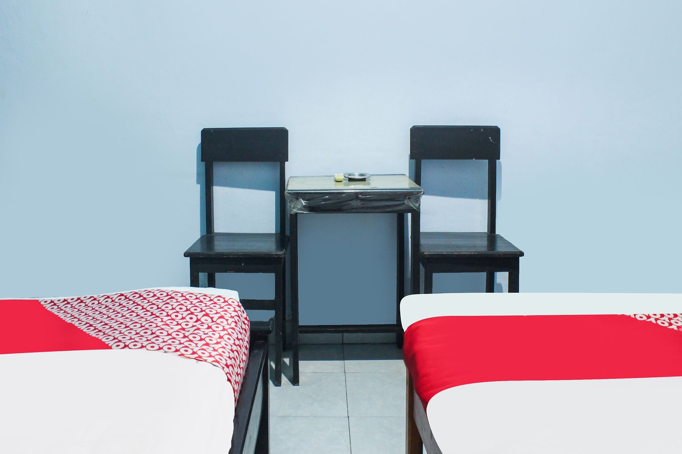 A room with two beds, a small table, and two chairs.