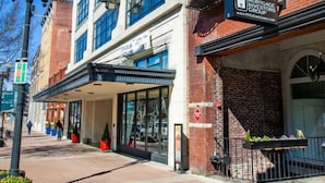 En byggnad med flera våningar, med en tydlig skylt som visar ordet ”STARCH”, en butik med skylten ”MORTGAGE INVESTORS GROUP” och en fasad av tegel med brandtrappor.