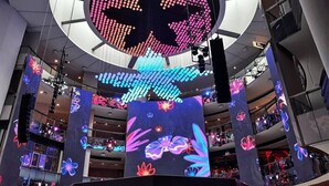 A modern interior with a large circular LED display and illuminated columns.