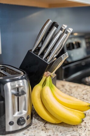 Eine Küchenarbeitsplatte mit einem Toaster und einem Messerblock mit Messern.