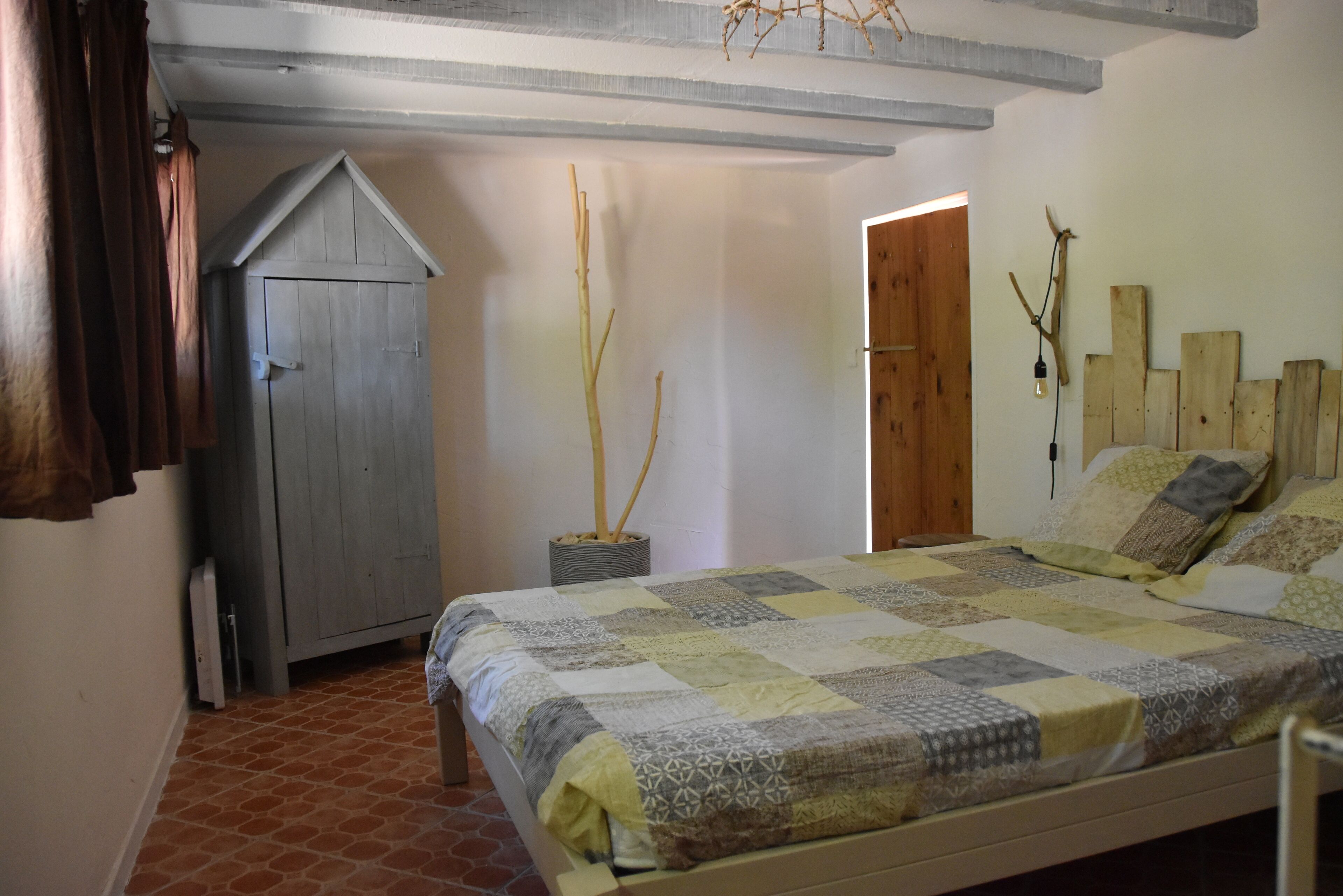 Un dormitorio con una cama, un armario de madera y una puerta.