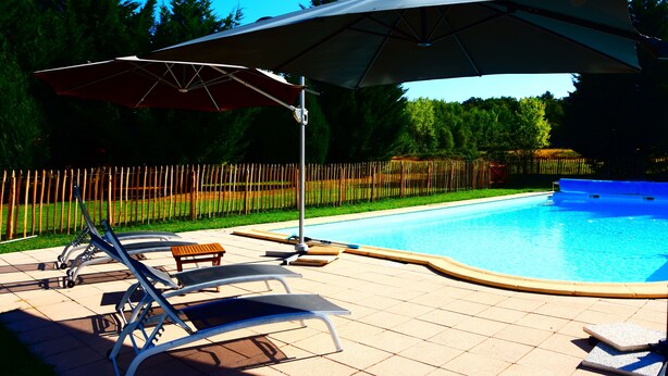 Ein Pool mit Liegestühlen und Sonnenschirm.