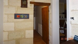 A hallway with stone walls, a wooden door, and a small framed picture. - Gite DE LA Lande ST Jean (SAINT-LOUBES)