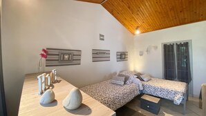 Une chambre avec deux lits, un bureau en bois et des œuvres d’art murales.